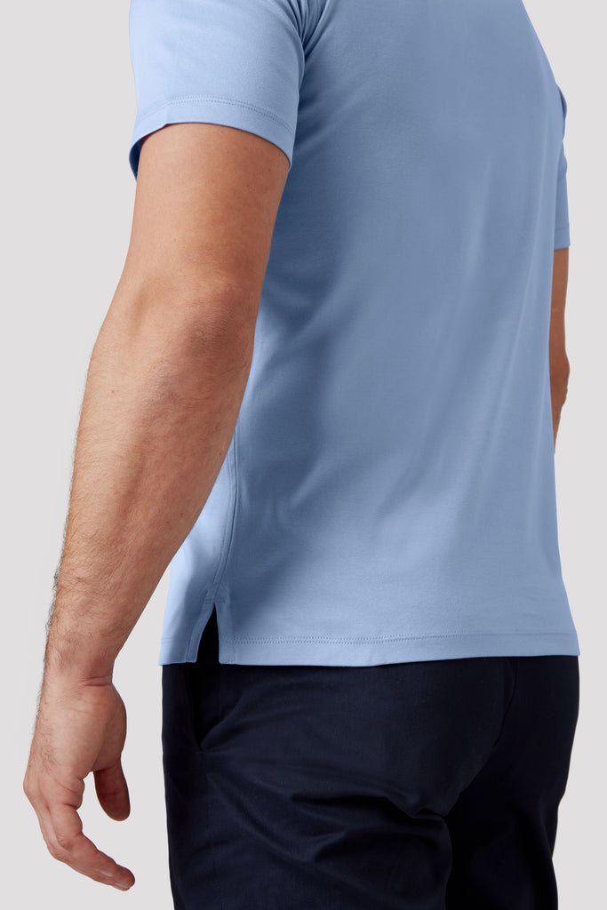 Side view of model wearing men's blue polo shirt made from Egyptian cotton