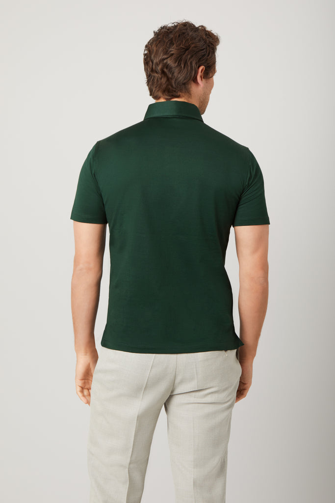 Rear view of model wearing men's Racing Green polo shirt made from Supima cotton